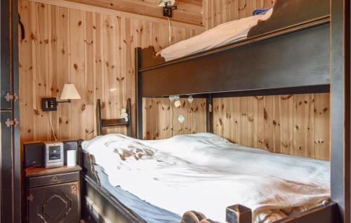 a bed in a room with a wooden wall at Cozy Home In Hemsedal With Kitchen in Hemsedal