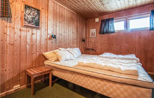 a bedroom with a bed in a wooden wall at Amazing Home In Trysil With 3 Bedrooms And Sauna in Trysil