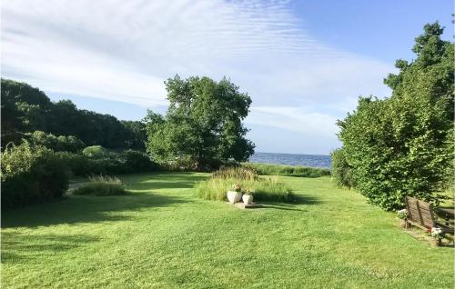 a field of grass with a view of the water at Amazing Home In Fjälkinge With Wifi in Fjälkinge