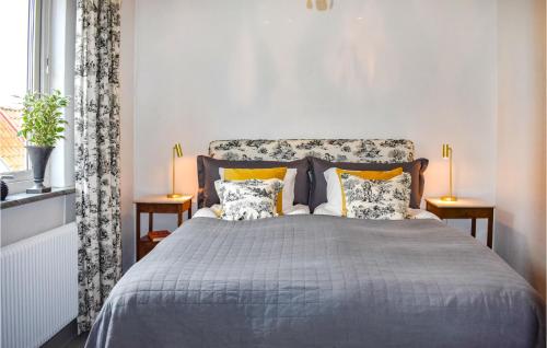 1 dormitorio con 1 cama con 2 mesas y 2 lámparas en 4 Bedroom Beautiful Home In Ystad, en Ystad