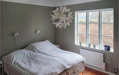 a bedroom with a bed and a window and a chandelier at Awesome Home In Bjärnum With Wifi in Bjärnum