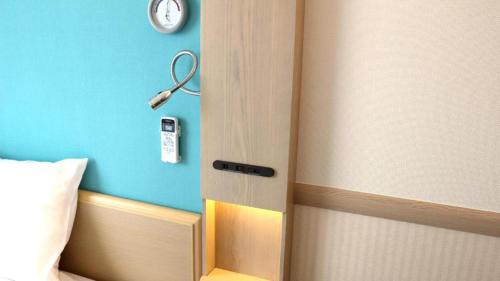 a room with a door with a clock on the wall at Toyoko Inn Fujisan Otsuki-eki in Ōtsuki