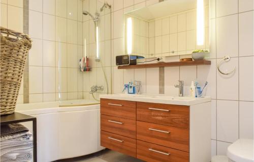 een badkamer met een wastafel, een bad en een spiegel bij 2 Bedroom Stunning Apartment In Kristiansand in Kristiansand