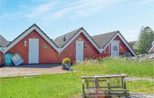 a red house with a deck in front of it at Lovely Home In Søgne With Wifi in Søgne