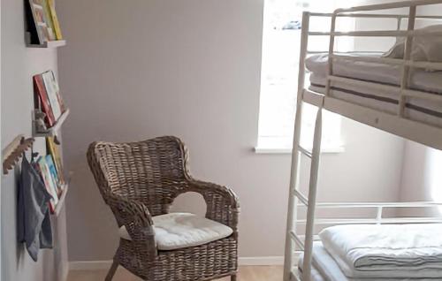 a bedroom with a rattan chair next to a bunk bed at Nice Home In Västervik With Wifi in Västervik