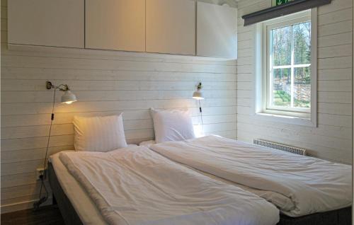 Schlafzimmer mit einem Bett mit weißer Bettwäsche und einem Fenster in der Unterkunft Amazing Home In Kosta With 1 Bedrooms And Wifi in Kosta