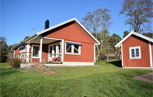 a red house with a green yard at Cozy Home In Rockneby With Kitchen in Rockneby