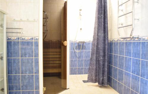 a bathroom with blue tiled walls and a shower at Cozy Home In Rockneby With Kitchen in Rockneby