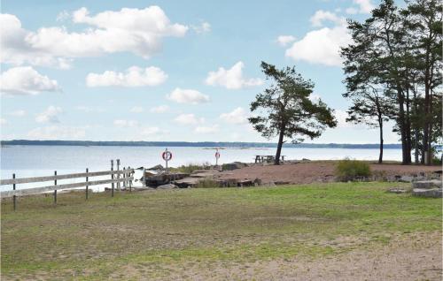 a beach with a fence and a body of water at 3 Bedroom Awesome Home In Oskarshamn in Oskarshamn