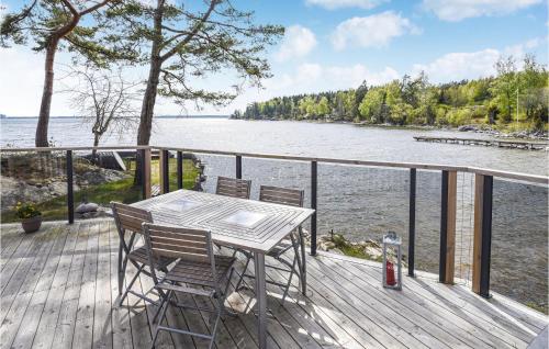a table and chairs on a deck next to the water at 3 Bedroom Beautiful Home In Lidköping in Lidköping