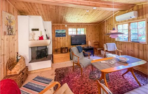 a living room with a table and a fireplace at Gorgeous Home In Mollaryd With Wifi in Mollaryd