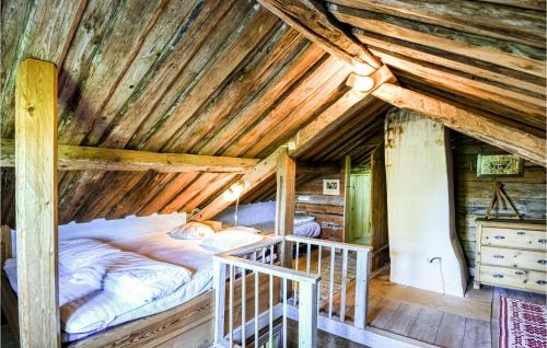 uma cama num chalé de madeira com tecto de madeira em Amazing Home In Lidkping With Kitchen em Lidköping