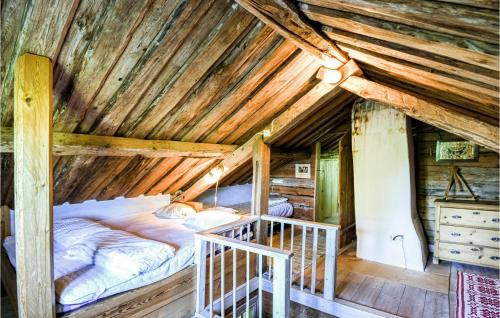 a bed in a log cabin with a wooden ceiling at Amazing Home In Lidköping With Kitchen in Lidköping
