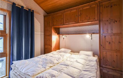 a bed in a room with wooden cabinets at Awesome Home In Bohus-malmn With 1 Bedrooms And Wifi in Bohus-Malmön