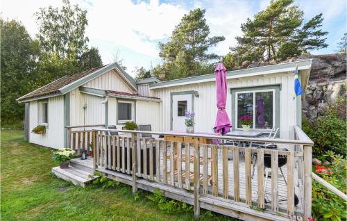 a small white cottage with a porch and a deck at Lovely Home In Strömstad With Wifi in Strömstad