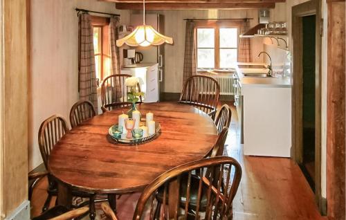 a kitchen and dining room with a wooden table and chairs at Awesome Home In Gusum With Sauna in Gusum