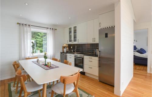 a kitchen with a table and chairs and a refrigerator at Stunning Home In Mellerud in Mellerud