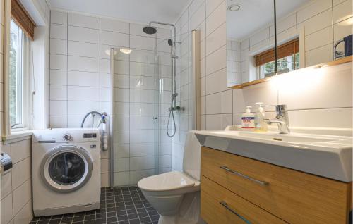 ein Badezimmer mit einer Waschmaschine und einem Waschbecken in der Unterkunft Awesome Home In Mellerud With Lake View in Mellerud