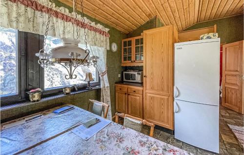 a kitchen with a table and a refrigerator at Amazing Home In Höviksnäs With Kitchen in Höviksnäs