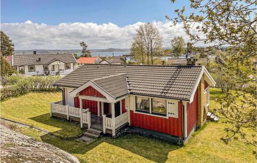 a red and white house on a grassy field at Amazing Home In Höviksnäs With Kitchen in Höviksnäs