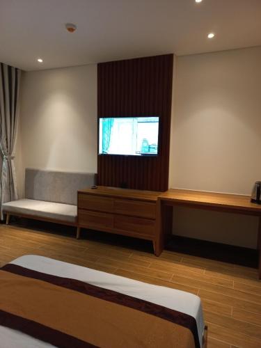 a room with a bed and a tv on the wall at Apec 5 sao TP.Tuy Hòa - View biển và view hồ bơi in Ðông Tác (1)