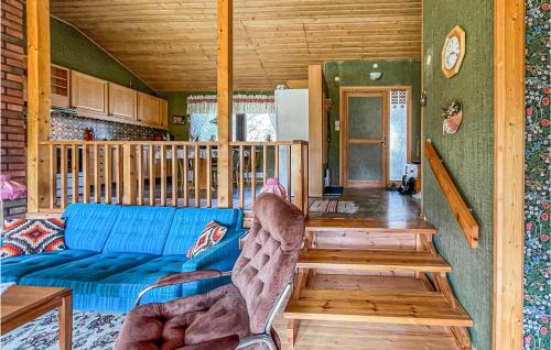 een woonkamer met een blauwe bank in een hut bij Amazing Home In Hviksns With Kitchen in Höviksnäs