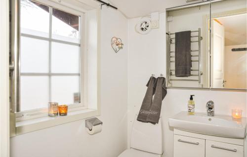 a white bathroom with a sink and a window at 3 Bedroom Amazing Home In Strngns in Strängnäs