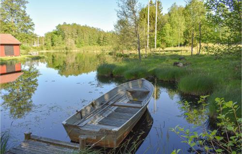 a wooden boat sitting in the middle of a lake at Stunning Apartment In Rönneshytta in Rönneshytta