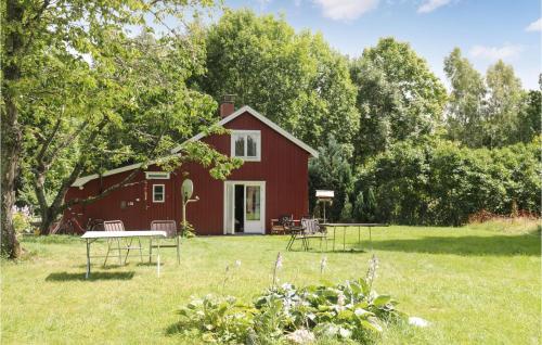 a red barn with a picnic table in the yard at Cozy Home In Dals-Rostock With Kitchen in Dals Rostock