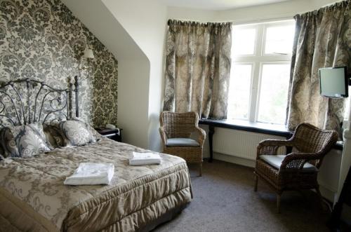 - une chambre avec un lit, deux chaises et une fenêtre dans l'établissement Glendale Hotel, à Cardiff