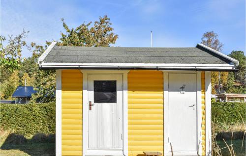 a yellow and white shed with a white door at 2 Bedroom Stunning Home In Kolmården in Kolmården