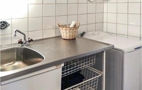 a kitchen counter with a sink and a basket on it at Amazing Home In Valdemarsvik With Wifi And 3 Bedrooms in Valdemarsvik