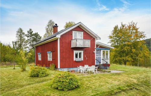 a red house with a balcony and a table at 2 Bedroom Pet Friendly Home In Ekshärad in Ekshärad