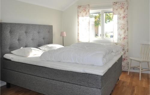 um quarto com uma cama grande com lençóis brancos e uma janela em Awesome Home In Sffle With House A Panoramic View em Säffle