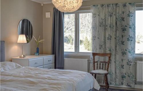 a bedroom with a bed and a chair and a window at Beautiful Home In Strngns With Sauna in Strängnäs