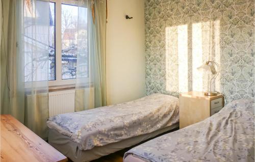 アルビカにある3 Bedroom Awesome Home In Arvikaのベッドルーム1室(ベッド2台、窓付)