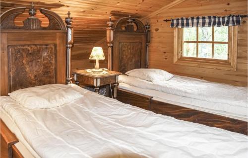 1 dormitorio con 2 camas en una cabaña de madera en Amazing Home In rjng With Kitchen en Årjäng
