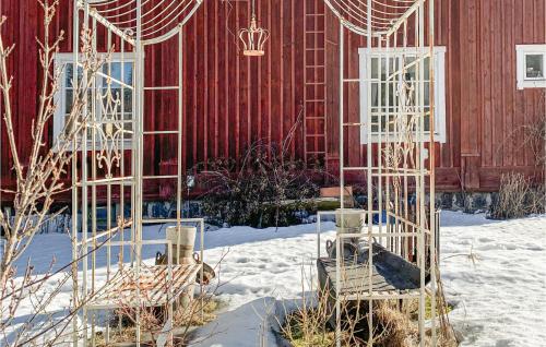 two chairs in the snow in front of a red building at Stunning Apartment In ngelsberg With Kitchen in Ängelsberg