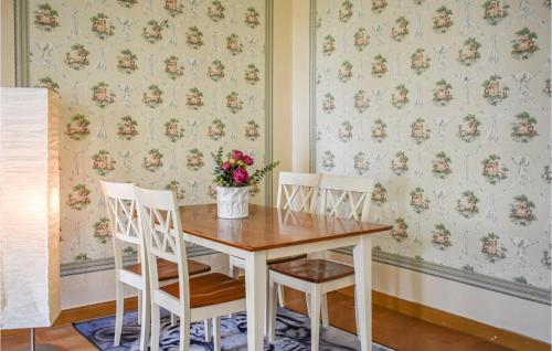 a table with two chairs and a vase with flowers at Cozy Home In Klockrike With Wifi in Klockrike