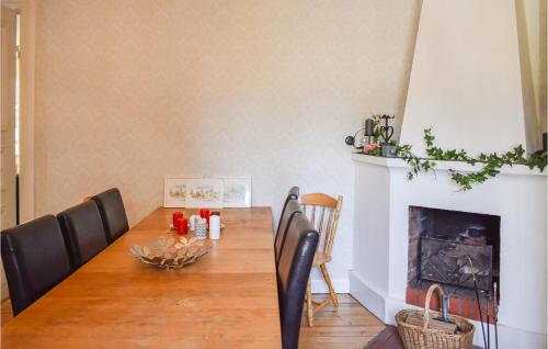 a dining room with a table and a fireplace at Cozy Home In Klockrike With Wifi in Klockrike