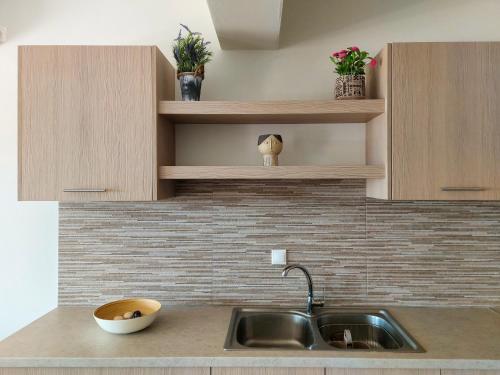 encimera de cocina con fregadero y armarios de madera en Villa Harmonia, en Aegina Town