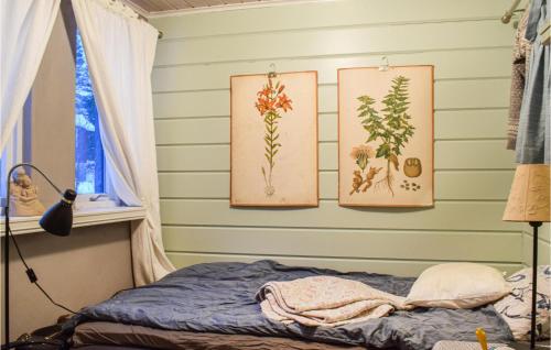 a bedroom with three paintings on the wall at Awesome Home In Eikefjord With 3 Bedrooms And Wifi in Eikefjord