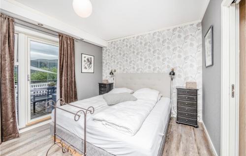 een slaapkamer met een wit bed en een raam bij Stunning Home In Vestnes With 3 Bedrooms And Wifi in Vestnes
