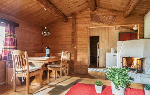 ein Esszimmer mit einem Kamin in einem Blockhaus in der Unterkunft Gorgeous Home In Atna With Wifi in Atnoset