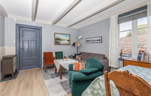 a living room with a blue door and a couch and a table at 2 Bedroom Stunning Apartment In Åfarnes in Åfarnes