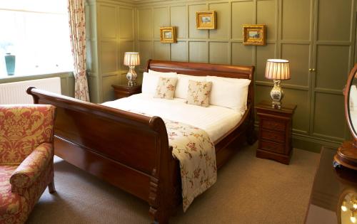 a bedroom with a bed and two lamps and a chair at The Wrea Head Hall Country House Hotel & Restaurant in Scarborough