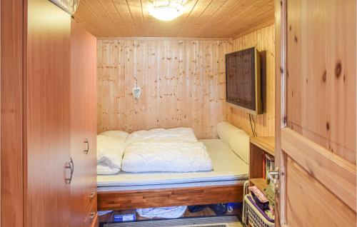 um pequeno quarto com uma cama e uma televisão em Awesome Home In Nord-torpa With Kitchen em Nord Torpa