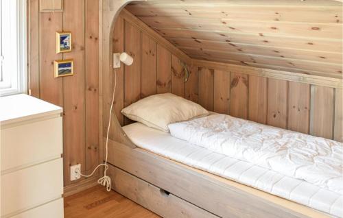 Amazing Home In Mesnali With Wifi في Mesnali: سرير في غرفة بجدار خشبي