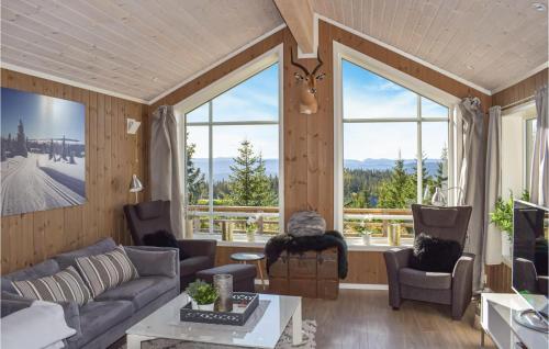 una sala de estar con paredes de madera y ventanas grandes. en Stunning Home In Øyer With Wifi, en Øyer