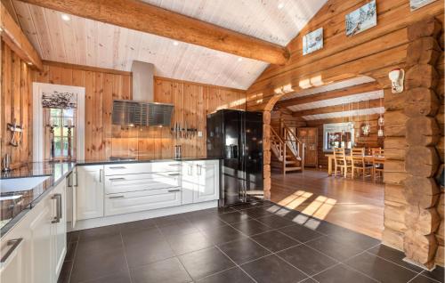 a kitchen with wooden walls and a kitchen with a refrigerator at Gorgeous Home In Lampeland With Kitchen in Lampeland